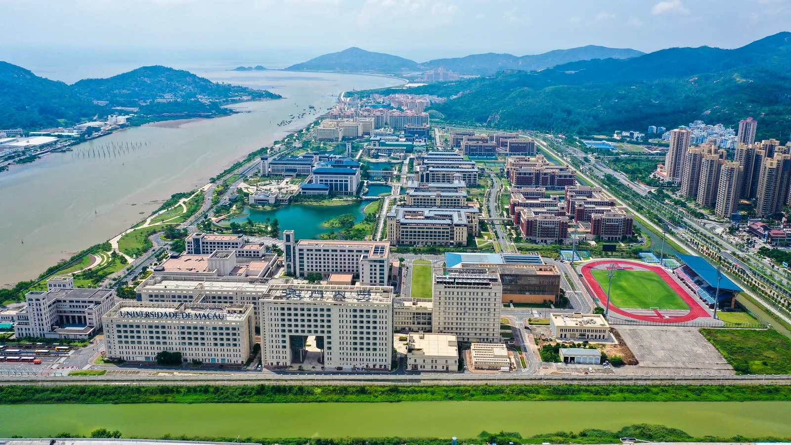 Daytime aerial panorama of the University of Macau campus beside the river